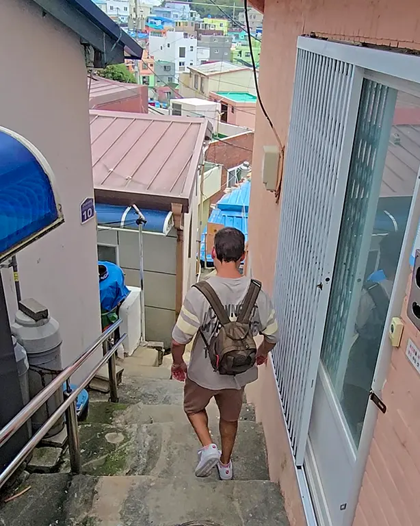 Joan bajando por unas escaleras empinadas en una calle de Gamcheon Culture Village