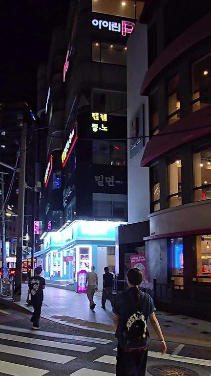 Personas cruzando pasos de peatón en una calle de Gwangalli