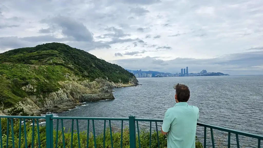 vistas desde un mirador hacia rocas y árboles con Busan de fondo