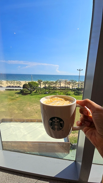 Noelia sosteniendo un café en el Starbucks del Grand Josun Busan,