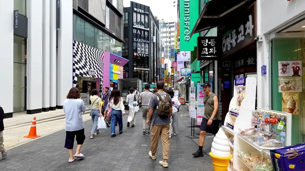 Joan paseando por las calles de Myeongdong rodeada de tiendas de cosmética coreana
