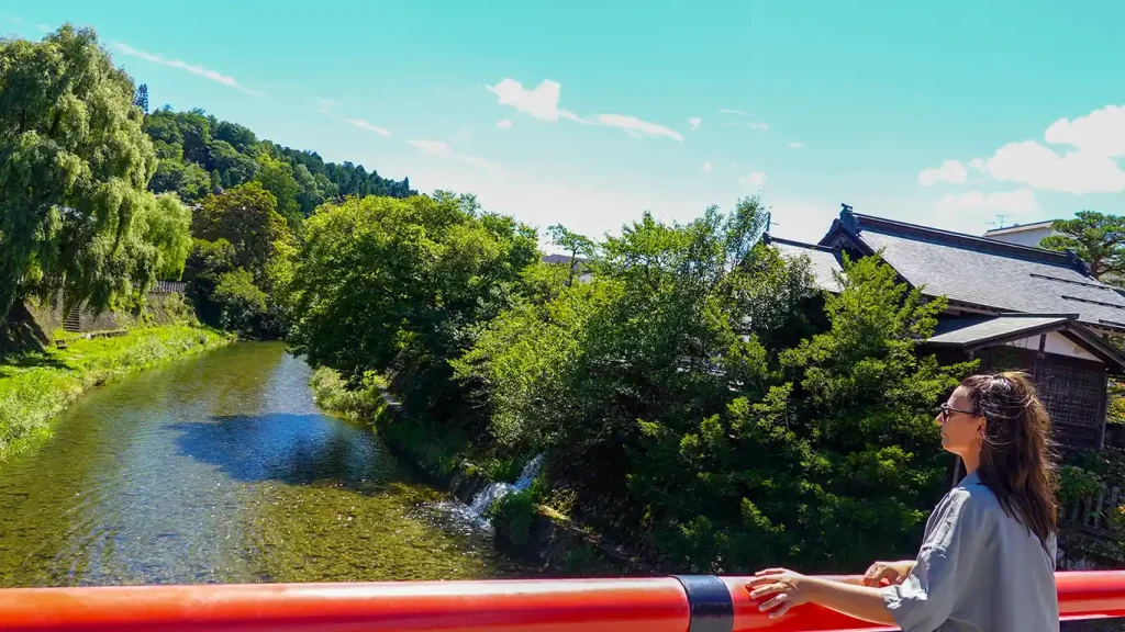 Río lleno de naturaleza en Takayama con un roykan al fondo
