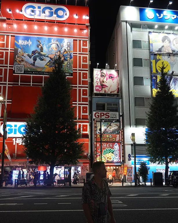 Barrio Akihabara lleno de luces por la noche en los edificios de manga friki