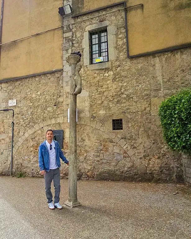 Joan junto a la columna del cul de la Lleona en Girona