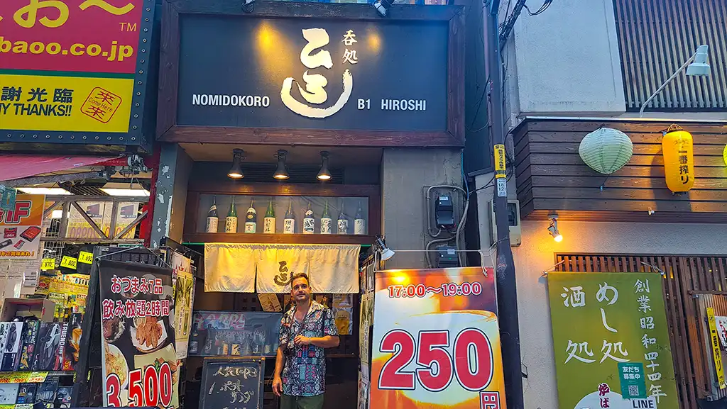 Joan en las escaleras del izakaya subterráneo con cartel de prohibido extranjeros en Akihabara.