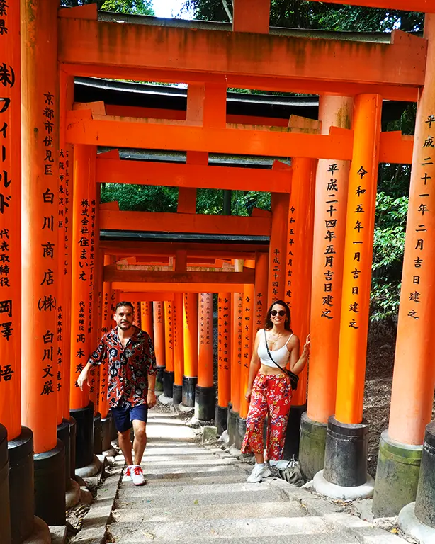 Noelia y Joan caminando bajo los torii rojos de Fushimi Inari.