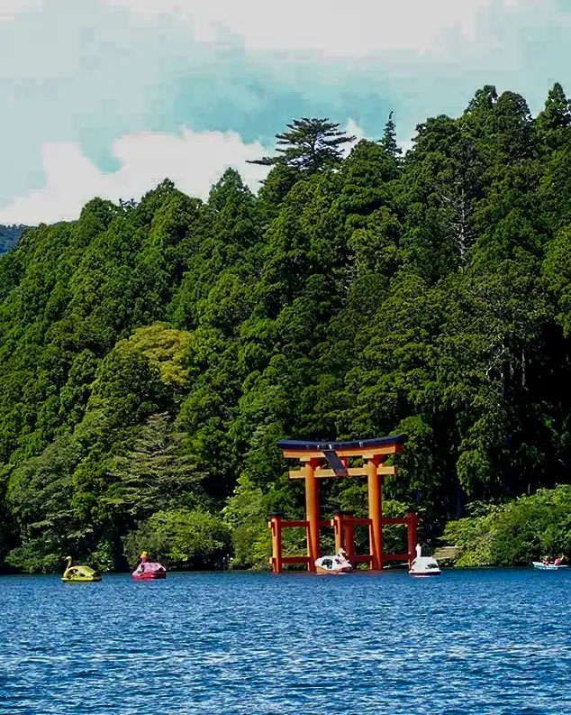 Vistas lejanas del Torii rojo flotante sobre las aguas del lago Ashi.