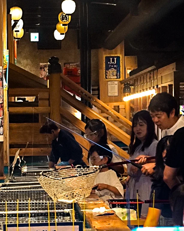 Turistas pescando en las peceras de un restaurante en Shinsekai.