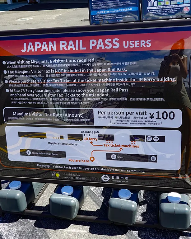 Cartel informativo sobre la tasa turística de Miyajima.