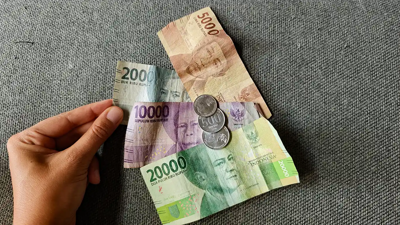 Noelia sujetando Rupias indonesias para pagar gastos del viaje.