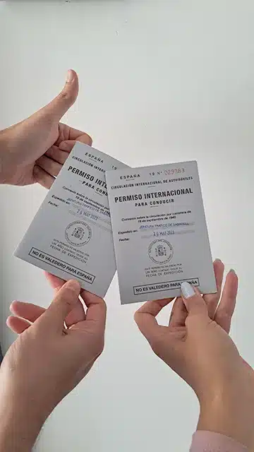 Joan y Noelia sujetando su Permiso Internacional de Conducir.