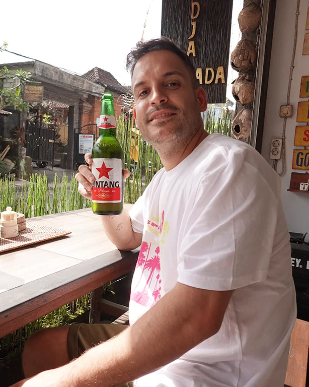 Joan sosteniendo una cerveza Bintang bien fría en Indonesia.