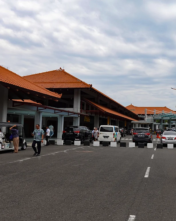 Zona de llegadas del aeropuerto de Bali rodeada de taxistas.