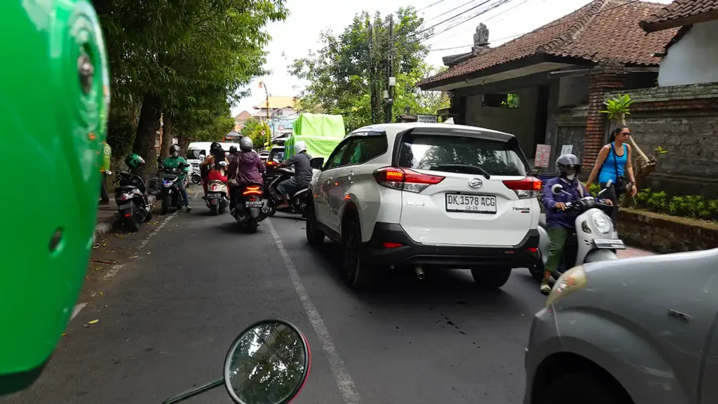 Tráfico intenso de coches y motos en una carretera de Bali.