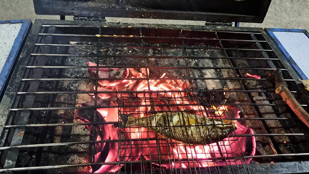 Pescado cocinándose a la parrilla sobre las brasas en Indonesia.