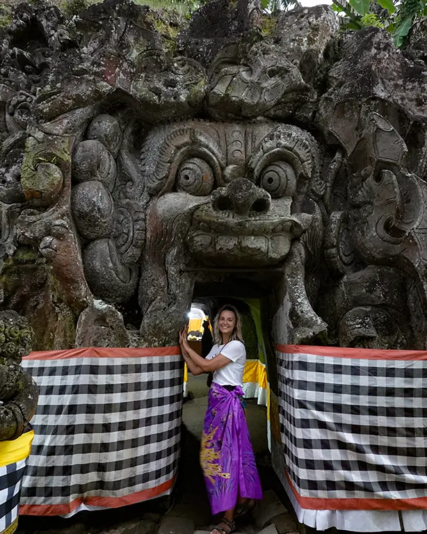 Noelia frente a la entrada tallada en roca de la Cueva del Elefante en Ubud.