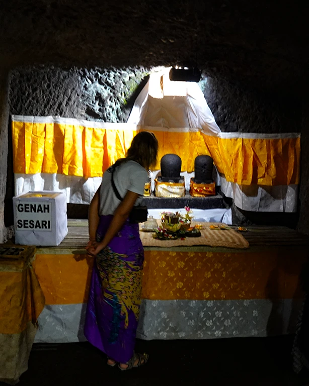 Noelia observando el interior de Goa Gajah junto a la estatua del dios Ganesha.