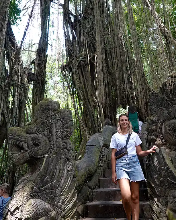 Noelia cruzando un puente de piedra rodeado de vegetación en el Monkey Forest.