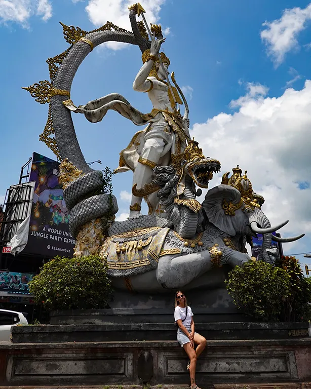 Noelia sonriendo junto al imponente Monumento de Arjuna en una rotonda de Ubud.