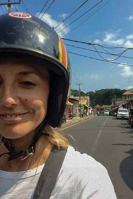 Noelia con casco de moto circulando por Bali.