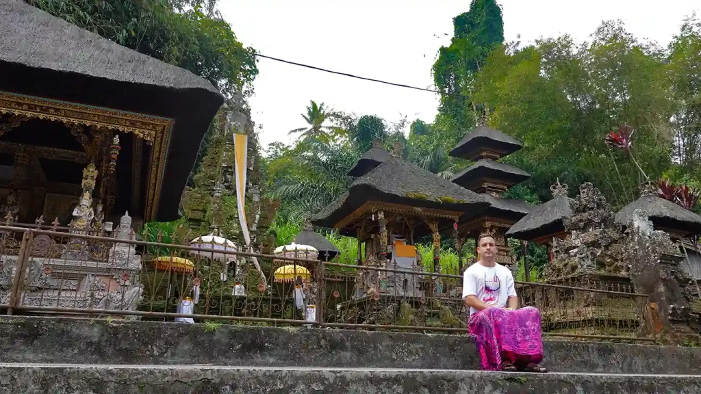 Joan con el sarong tradicional en un santuario con pequeños templos de techo de paja en Bali.
