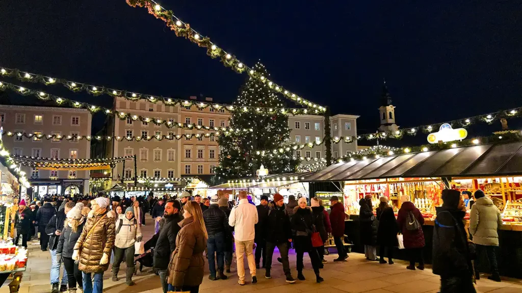 Salzburger Christkindlmarkt iluminado de noche en Residenzplatz.