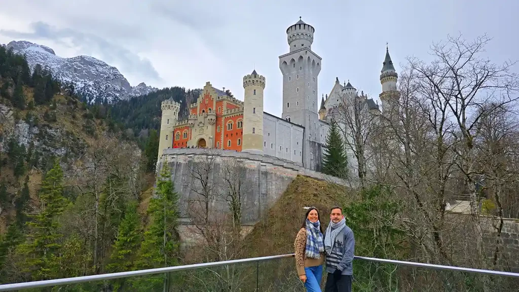 Pareja frente al castillo de Neuschwanstein en invierno.