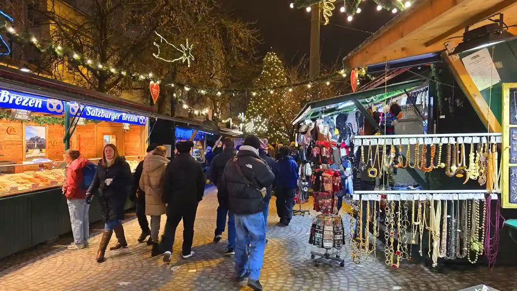 Puestos del mercado de Navidad de Mirabellplatz de noche.